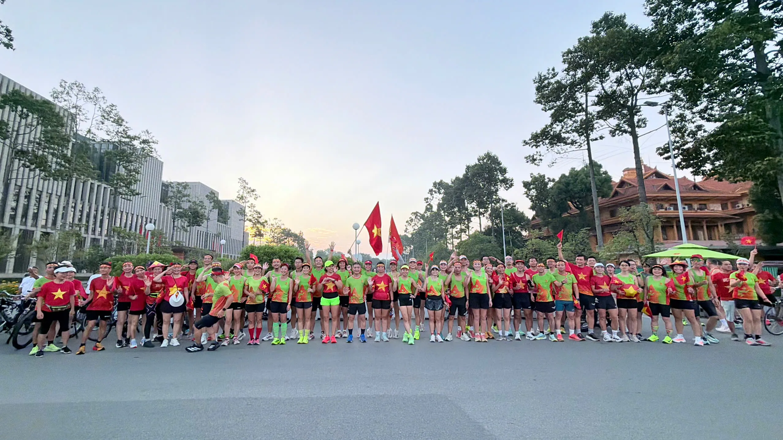 Cả đoàn xếp hàng ngang trên phố dưới ánh bình minh gần Ba Đình