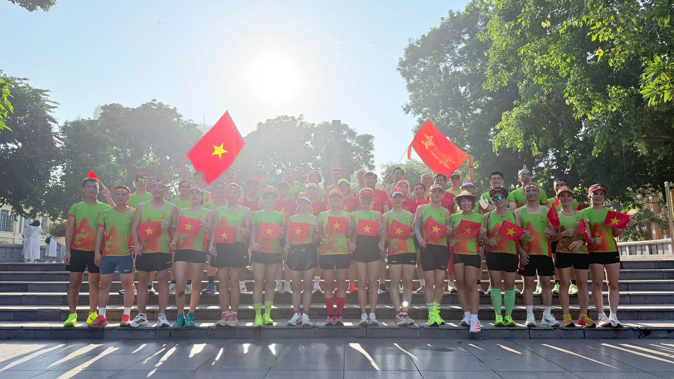 Đoàn Starlake chụp ảnh dưới tượng đài vua Lý Thái Tổ bên Hồ Gươm