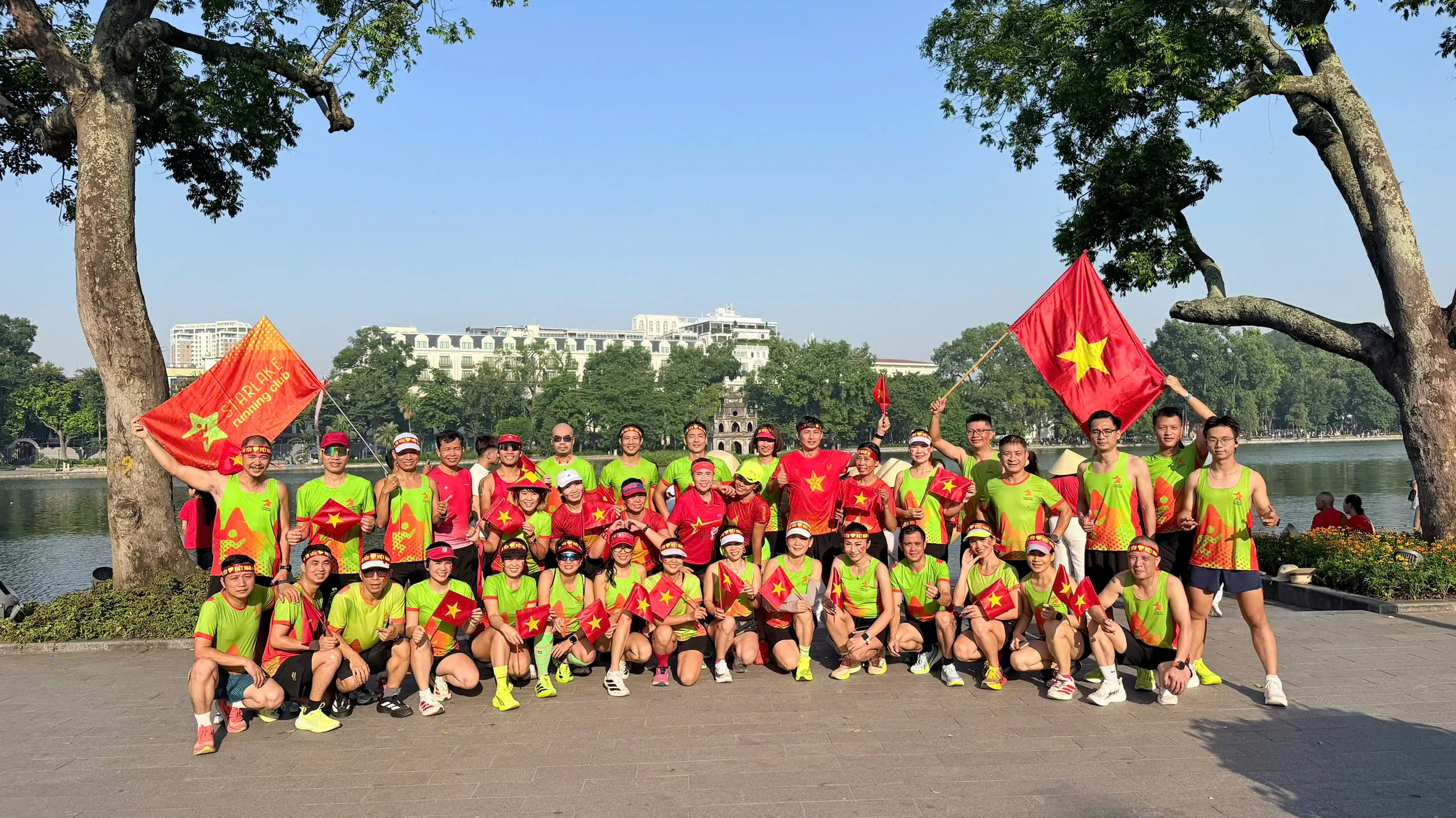 Đoàn Starlake chụp ảnh bên Hồ Gươm với Tháp Rùa phía xa