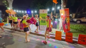 Thành viên Starlake cầm pom-pom và cờ cam nhảy múa trước biển Hà Nội Vibes 18/10/2026 lúc 1h28 sáng