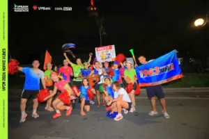 Cả đội cổ vũ cùng các bạn mang cờ 1983 Vietnam Runners tạo dáng vui nhộn với pom-pom, kèn và cây đàn guitar giữa đường